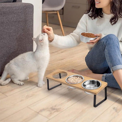 une femme donne des croquettes à un chat blanc près Gamelle surélevée 3 bols 
