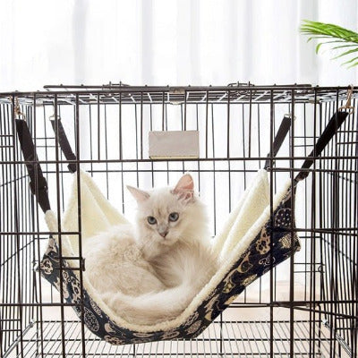 Hamac suspendu pour chat à crochets métalliques avec un chat blanc couché dessus